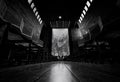 Perspective view in church. A few people sit on wooden bench with many of empty bench in church on Sunday. Black and white scene