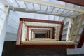 View down to geometrical stairway of marble steps, wooden rails