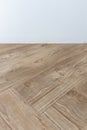 Perspective view of empty interior room with white cement wall and brown wooden herringbone floor Royalty Free Stock Photo