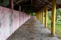 Perspective view of an empty small building with a wall and some yellow pillars