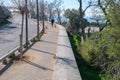 Perspective view on footpath with walking unknown people along the Mediterranean sea