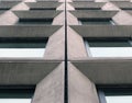 perspective view of geometric angular concrete windows on the facade of a modernist 1960s brutalist style building Royalty Free Stock Photo