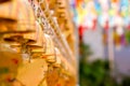 Perspective view group of small golden bells hang in Thai temple on blurry background Royalty Free Stock Photo