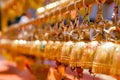 Perspective view group of small golden bells hang in Thai temple on blurry background Royalty Free Stock Photo