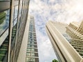 Perspective view high rise real estate of hotel apartment condo tower building with cloud blue sky and sun flare background Royalty Free Stock Photo