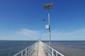 Perspective view of jetty with LED street light with solar cell on clear blue sky. Royalty Free Stock Photo