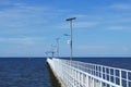 Perspective view of jetty with LED street light with solar cell on clear blue sky. Royalty Free Stock Photo