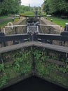 A perspective view of lock gates on the calder and hebble navigation canal at sowerby bridge in west yorkshire with town buildings Royalty Free Stock Photo