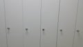 Perspective view of lockers or cupboards in a row with white doors Royalty Free Stock Photo