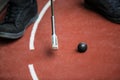 Perspective view from a minigolf player with a iron racket and a