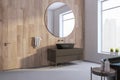 Perspective view of modern bathroom interior design with tiles grey floor, wooden wall, window with city view and mirror. 3D Royalty Free Stock Photo