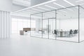 Perspective view of modern empty office hallway with futuristic design meeting room surrounded by glasses walls, concrete floor Royalty Free Stock Photo