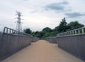 Perspective view of the pedestrian footbridge crossing the weir on the river aire at knostrop leeds with electricity pylons Royalty Free Stock Photo