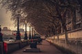 Perspective view of the riverside of Thames in London, with street lamps and trees decorated with Christmas lights Royalty Free Stock Photo