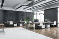 Perspective view on spacious coworking office with light concrete and wooden floor, brown tables with modern computers surrounded Royalty Free Stock Photo