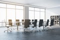 Perspective view of spacious empty conference room with office desk and chairs, window with city view, white walls and concrete Royalty Free Stock Photo