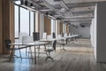 Perspective view on spacious sunlit coworking office with eco interior design, city view from big windows, wooden floor and wall Royalty Free Stock Photo