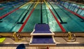 Perspective view at starting platform and quiet swimming pool with multicolored lane lines, no people scene Royalty Free Stock Photo