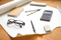 Perspective view on technical drawing setup, with pencil, compass, ruler, calculator, glasses, eraser and notebook Royalty Free Stock Photo