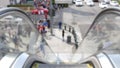 Perspective view thru escalator, defocused unrecognizable group of people on road intersection crosswalk on Strip of Las Vegas,