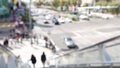 Perspective view thru escalator, defocused unrecognizable group of people on road intersection crosswalk on Strip of Las Vegas,