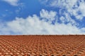 Perspective view of a tiled roof under a blue cloudy sky