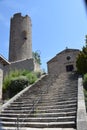 Perspective view of the tower and church of Chambles Loire France at the foot of the stone staircase