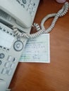 perspective view of two white wired telephones on a wooden table