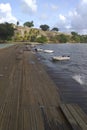 Perspective view of wet wooden jetty, choppy gray waters and moored zodiacs in the Caribbean Sea under tropical blue sky. Seascape Royalty Free Stock Photo