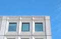 Perspective view of a white concrete office building against a bright blue sky with geometric brutalist 1960s details Royalty Free Stock Photo