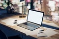 Perspective view on white modern blank laptop screen with place for your logo on illuminated office table with coffee cup on Royalty Free Stock Photo