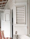 Perspective view of white wooden shutters and storm doors in traditional Caribbean colonial house. Architecture and construction
