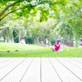 Perspective white wood over blur abstract green trees leaves nature with people background, product display montage, spring and Royalty Free Stock Photo