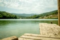 Perspective Wooden board empty table in front of blurred nature background with mountain and lake. Royalty Free Stock Photo