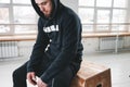 Perspiring athlete sitting on crossfit box after intense crossfit workout at gym