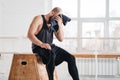 Perspiring fit sportsman resting after work session cross workout in light hall Royalty Free Stock Photo