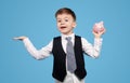 Persuasive schoolboy carrying piggy bank Royalty Free Stock Photo