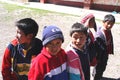 Peru Ayacucho, poor children in school studying in the mountains with row and teacher typical clothing in the Andes