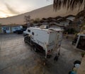 Pickup truck with attached trailer at hostel in Huacachina next to tents with sand dunes in
