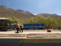 Workers at Ollantaytambo train station rail tracks, blue incarail and green perurail