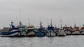 Multiple colored boats anchored side by side in the marina