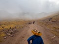 Indian group with traditional clothing walks in front of fog covered mountain range