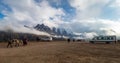 Parking lot for the rainbow mountain, tourist buses and indians with horses in the frame, snow