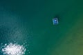 Peruca Lake. Floating platform with a sun tanning couple aerial top view. Bright sn reflecting in green lake waves. Dalmatia,