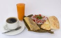 Peruvian breakfast called Tamal cooked corn mixed with chicken and wrapped in corn leaves. `Criolla salad` made with onion.
