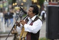 Peruvian busker, street musician, in national clothes playing the native wind instrument on a street