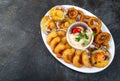 PERUVIAN FOOD. Piqueo caliente. Hot seafood platter fried shrimps, squid rings and baked scallops with sauce Royalty Free Stock Photo