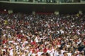 Peruvian football, soccer fans cheering for their team with flag stripes across the face of the stadium. Enthusiastic fans rejoice