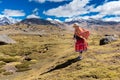 Peruvian indigenous old woman standing weaving traditional clothing