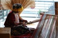 Peruvian indigenous woman is weaving a carpet.